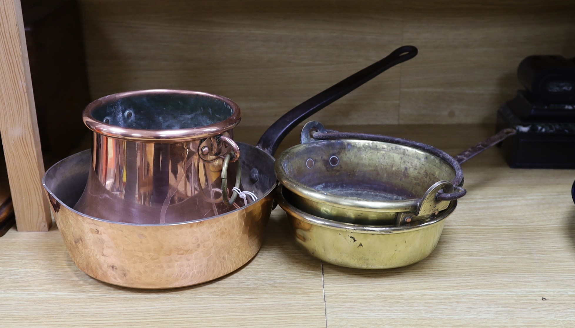 A French copper cooking pan, copper saucepan and two brass pans, largest 30cms diameter